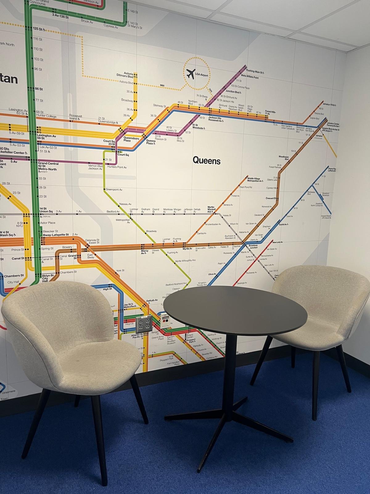 Mapa del metro de Nova York amb la icona d'un aeroport, dues cadires buides i una taula